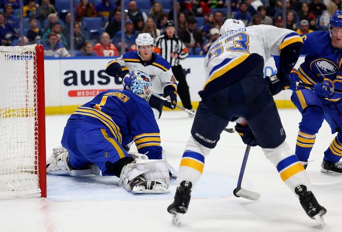 Feb 10, 2024; Buffalo, New York, USA;  St. Louis Blues left wing Jake Neighbours (63) scores on a backhanded shot against Buffalo Sabres goaltender Ukko-Pekka Luukkonen (1) during the first period at KeyBank Center.