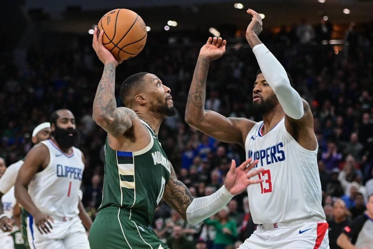 Mar 4, 2024; Milwaukee, Wisconsin, USA; Milwaukee Bucks guard Damian Lillard (0) drives for the basket against Los Angeles Clippers forward Paul George (13) in the fourth quarter at Fiserv Forum.