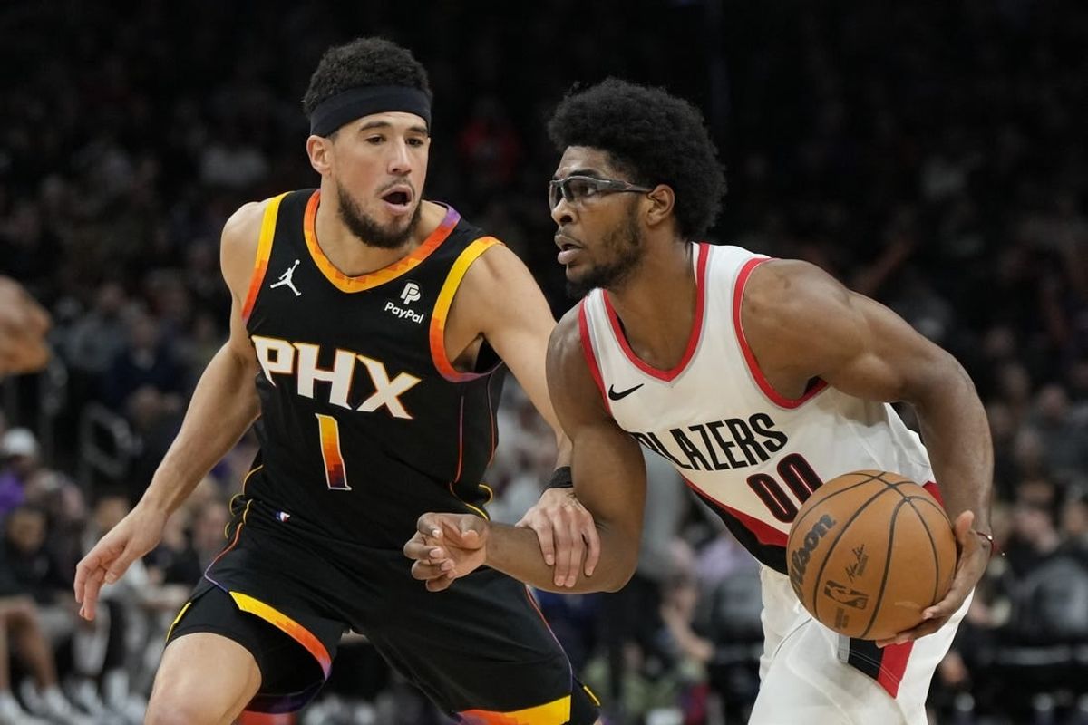 Jan 1, 2024; Phoenix, Arizona, USA; Portland Trail Blazers guard Scoot Henderson (00) drives on Phoenix Suns guard Devin Booker (1) in the second half at Footprint Center.