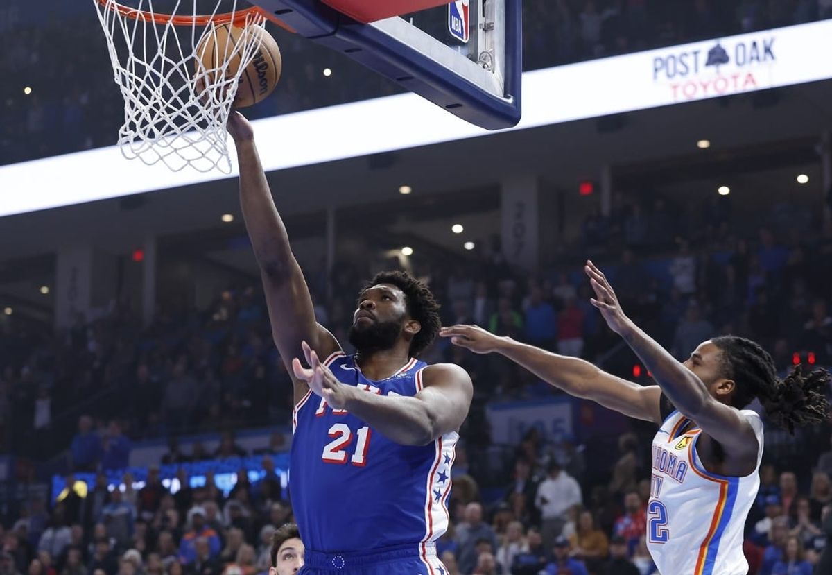 Nov 25, 2023; Oklahoma City, Oklahoma, USA; Philadelphia 76ers center Joel Embiid (21) shoots as Oklahoma City Thunder guard Cason Wallace (22) defends during the first quarter at Paycom Center.