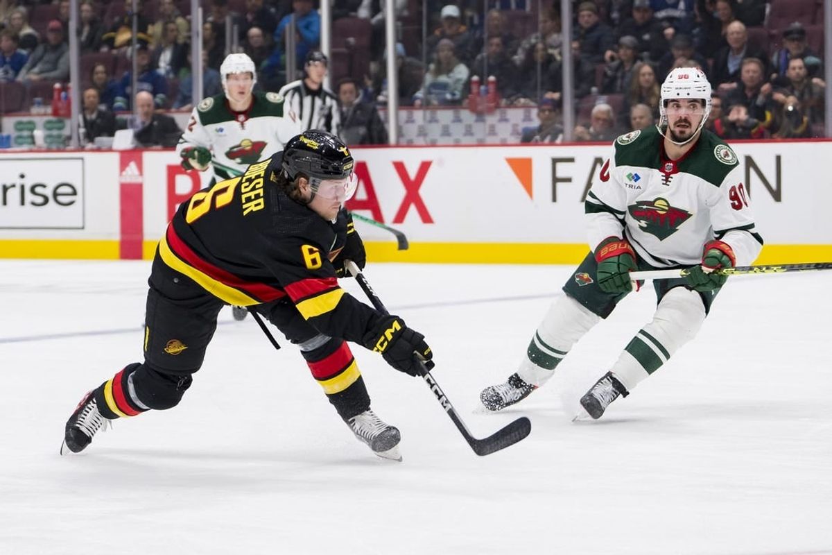 Mar 2, 2023; Vancouver, British Columbia, CAN; Minnesota Wild forward Marcus Johansson (90) watches as Vancouver Canucks forward Brock Boeser (6) shoots in the third period at Rogers Arena. Wild won 2-1.