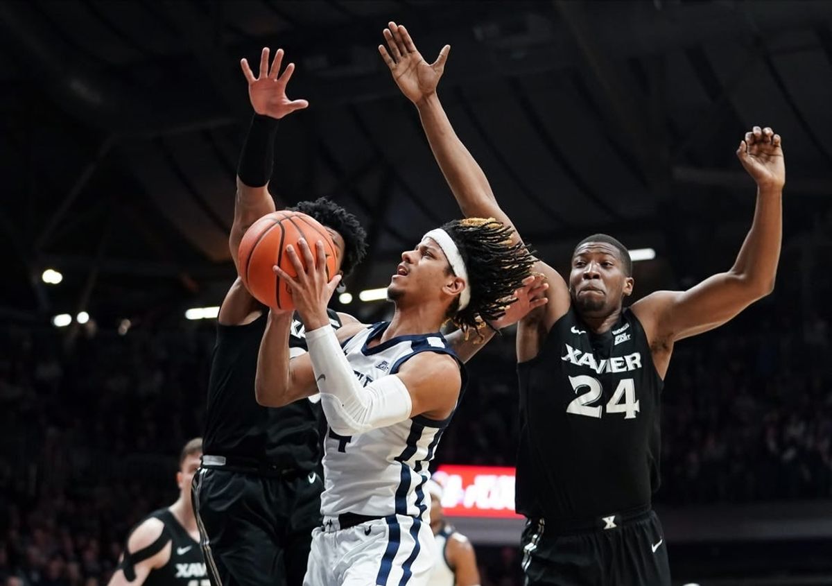 Mar 6, 2024; Indianapolis, Indiana, USA;  Butler Bulldogs guard DJ Davis (4) goes to the basket against Xavier Musketeers guard Dayvion McKnight (20) and Xavier Musketeers forward Abou Ousmane (24) during the first half at Hinkle Fieldhouse.