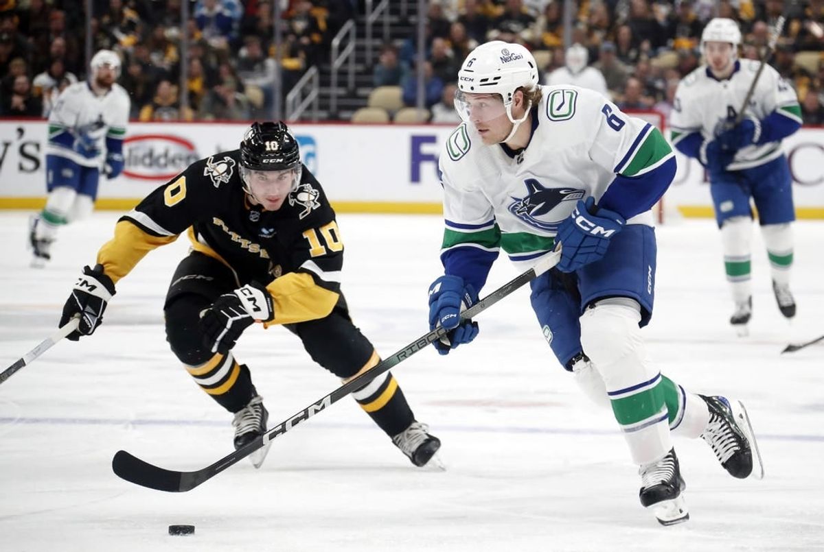 Jan 11, 2024; Pittsburgh, Pennsylvania, USA; Vancouver Canucks right wing Brock Boeser (6) skates up ice with the puck against Pittsburgh Penguins left wing Drew O'Connor (10) during the second period at PPG Paints Arena.