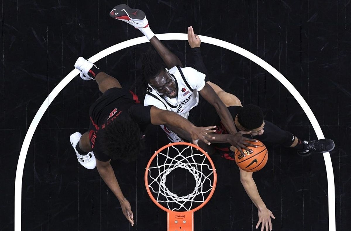 Jan 6, 2024; San Diego, California, USA; San Diego State Aztecs forward Jay Pal (center) goes to the basket defended by UNLV Rebels forward Rob Whaley Jr. (5) and guard Justin Webster (right) during the first half at Viejas Arena.