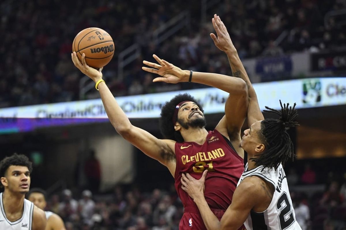 Jan 7, 2024; Cleveland, Ohio, USA; Cleveland Cavaliers center Jarrett Allen (31) shoots beside San Antonio Spurs guard Devin Vassell (24) in the second quarter at Rocket Mortgage FieldHouse.