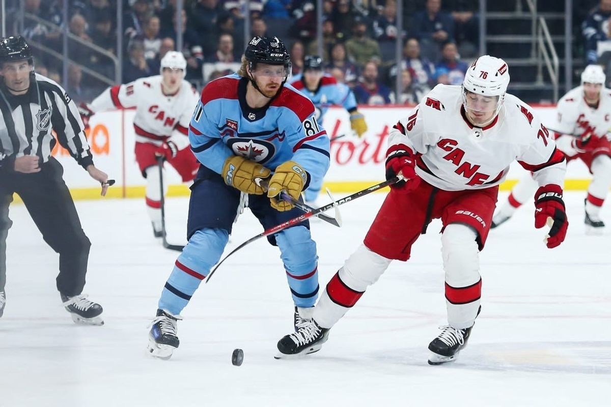 Dec 4, 2023; Winnipeg, Manitoba, CAN; Carolina Hurricanes defenseman Brady Skjei (76) and Winnipeg Jets forward Kyle Connor (81) go for the puck during the second period at Canada Life Centre.