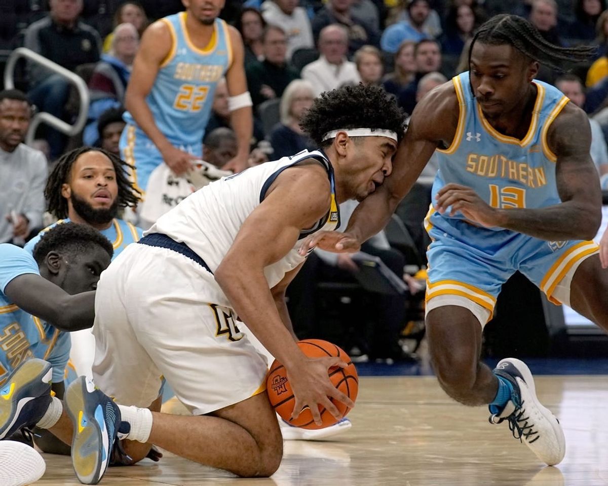 Nov 28, 2023; Milwaukee, Wisconsin, USA; Marquette Golden Eagles guard Stevie Mitchell (4) beats Southern Jaguars forward Delang Muon (35) and guard Dre'Shawn Allen (13) to a loose ball during the first half at Fiserv Forum.