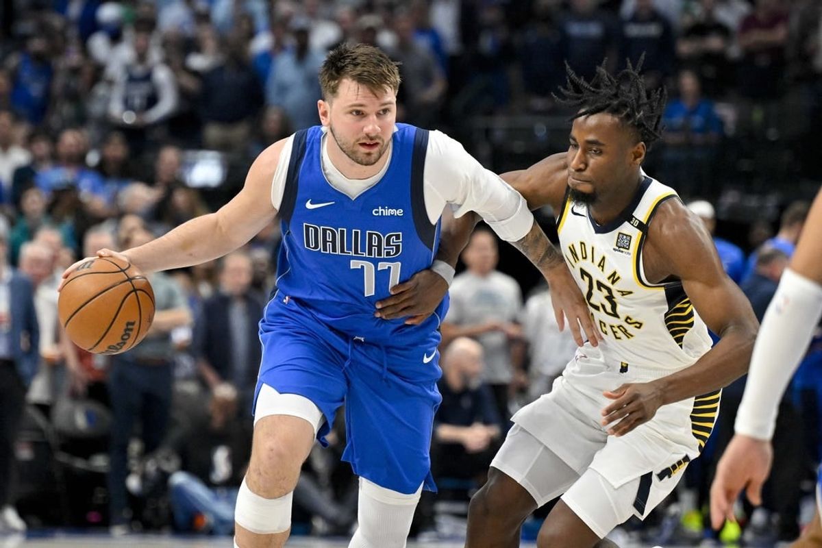 Mar 5, 2024; Dallas, Texas, USA; Dallas Mavericks guard Luka Doncic (77) looks to move the ball past Indiana Pacers forward Aaron Nesmith (23) during the first quarter at the American Airlines Center.