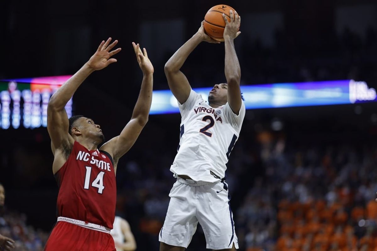 Jan 24, 2024; Charlottesville, Virginia, USA; Virginia Cavaliers guard Reece Beekman (2) shoots the ball as North Carolina State Wolfpack guard Casey Morsell (14) defends in overtime at John Paul Jones Arena.