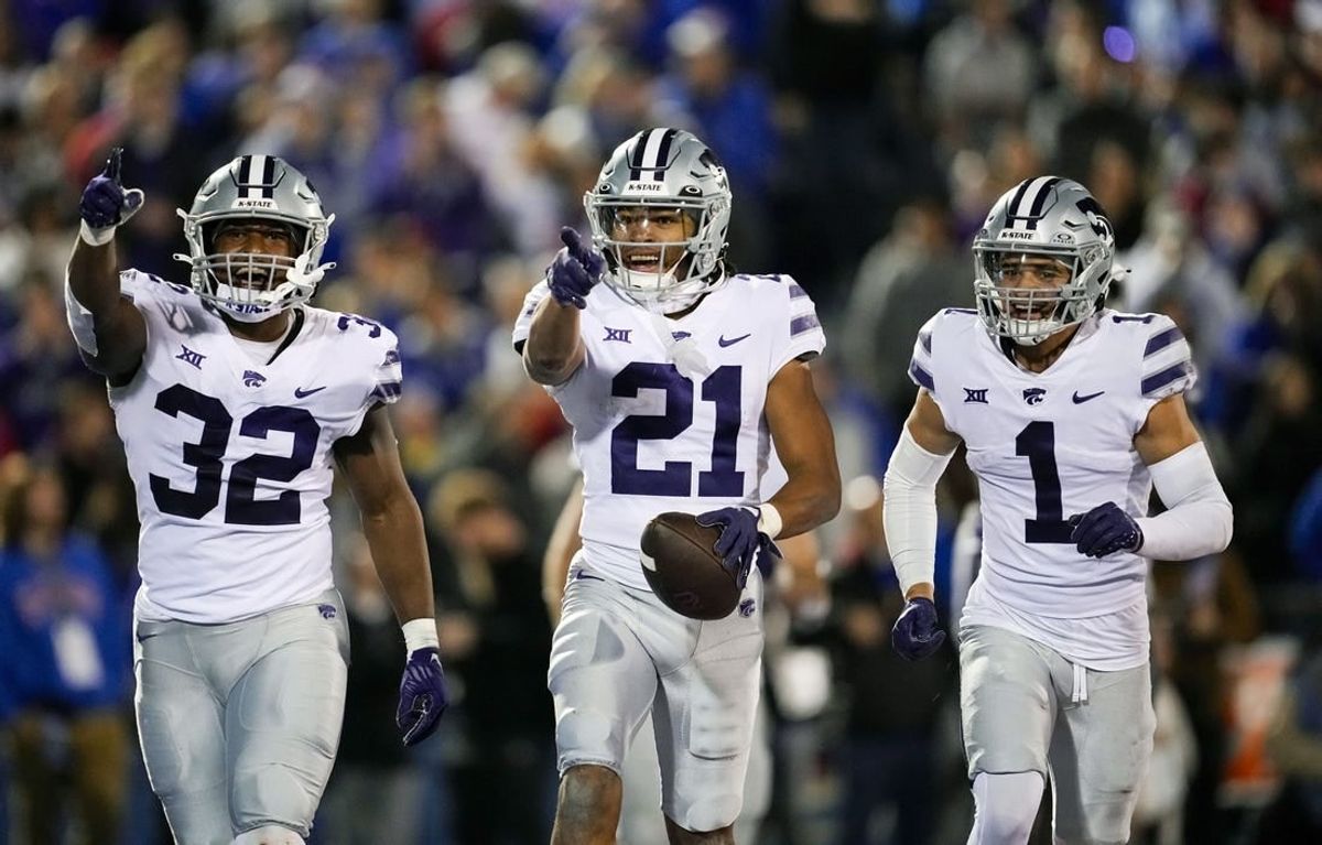 Nov 18, 2023; Lawrence, Kansas, USA; Kansas State Wildcats safety Marques Sigle (21) celebrates with linebacker Desmond Purnell (32) and cornerback Keenan Garber (1) after an interception during the second half against the Kansas Jayhawks at David Booth Kansas Memorial Stadium.
