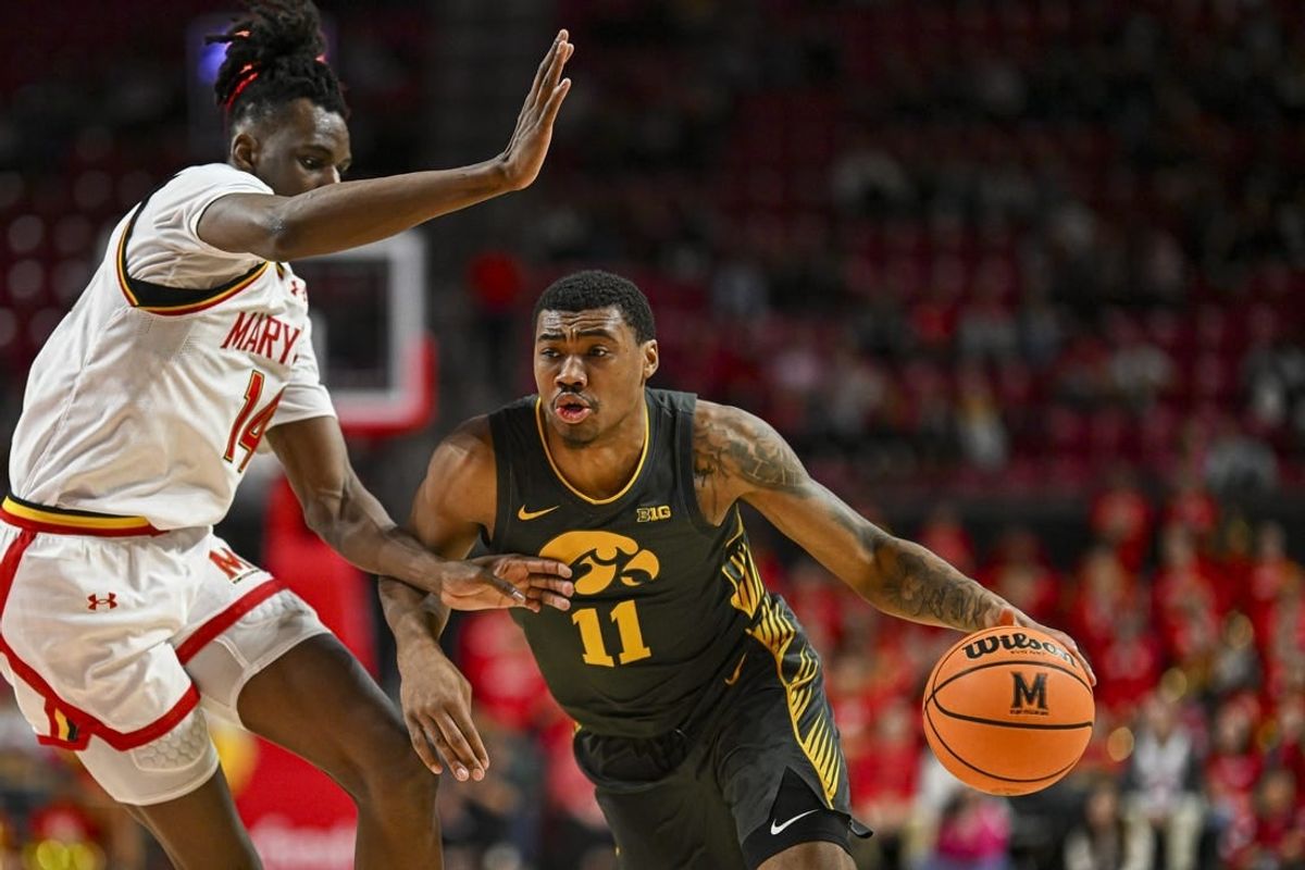 Feb 14, 2024; College Park, Maryland, USA;  Iowa Hawkeyes guard Tony Perkins (11) drive to the basket on Maryland Terrapins forward Mady Traore (14) during the fist half at Xfinity Center.