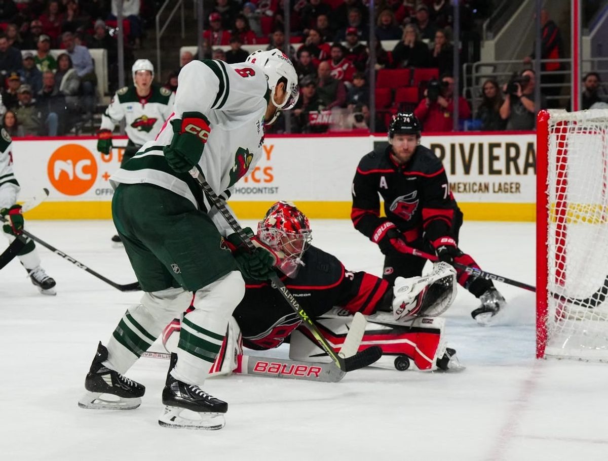 Jan 21, 2024; Raleigh, North Carolina, USA;  Carolina Hurricanes goaltender Antti Raanta (32) stops the scoring attempt by Minnesota Wild defenseman Dakota Mermis (6) during the second period at PNC Arena.