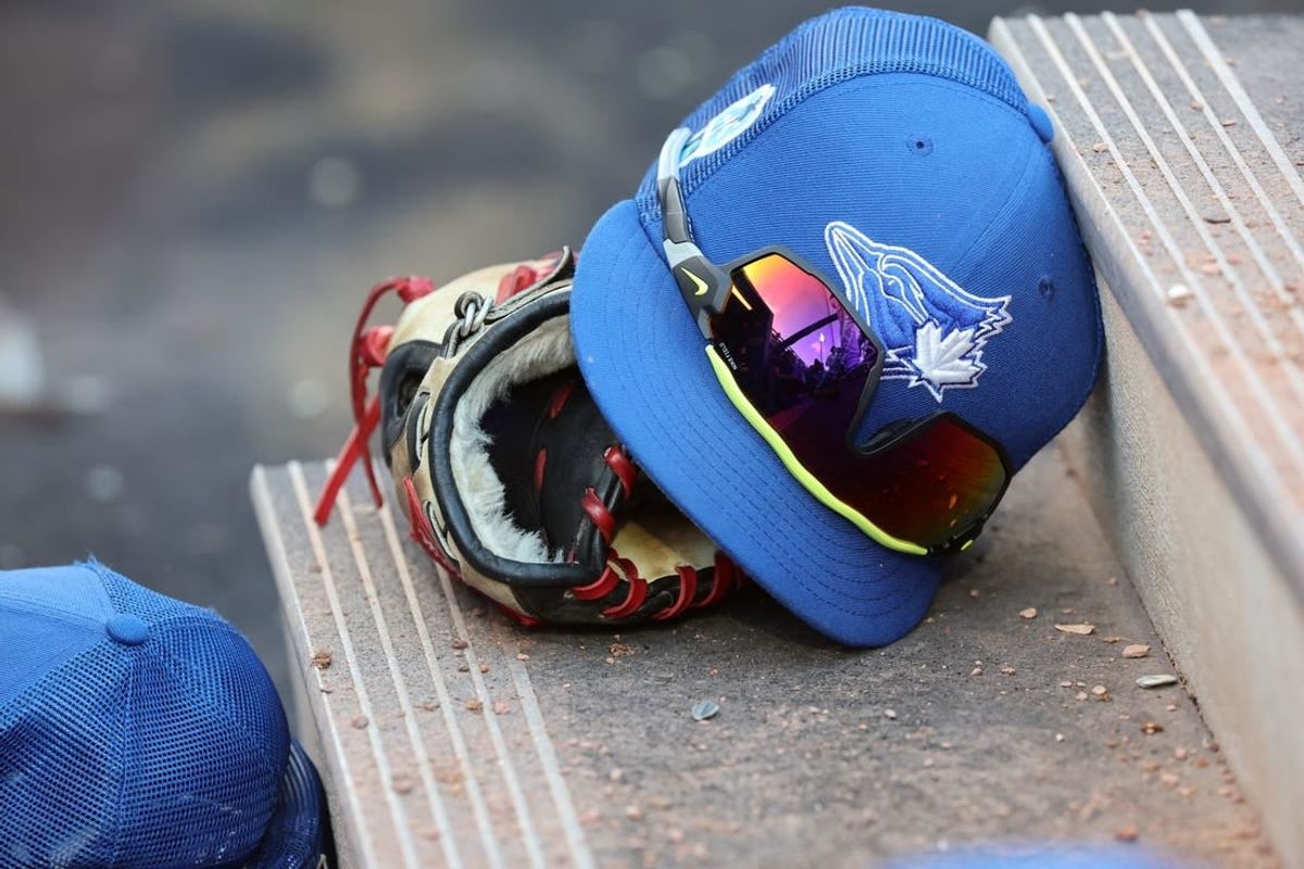 Mar 25, 2023; Dunedin, Florida, USA;  A detail view of Toronto Blue Jays hat and glove against the Detroit Tigers at TD Ballpark.
