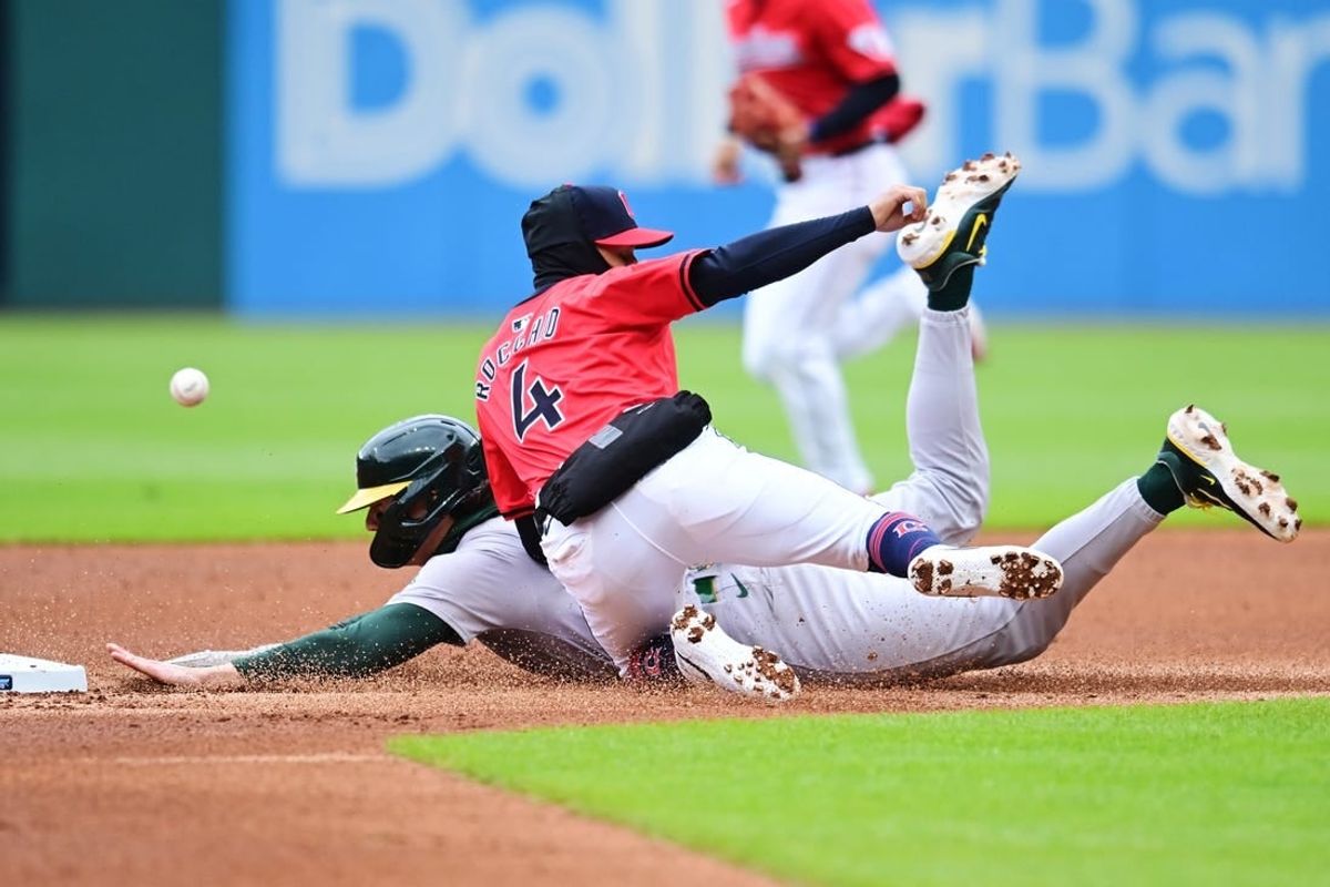Apr 21, 2024; Cleveland, Ohio, USA; Oakland Athletics second baseman Zack Gelof (20) steals second as Cleveland Guardians shortstop Brayan Rocchio (4) misses the throw during the second inning at Progressive Field.