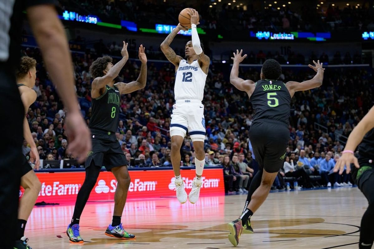 Dec 19, 2023; New Orleans, Louisiana, USA;  Memphis Grizzlies guard Ja Morant (12) shoots in between New Orleans Pelicans forwards Naji Marshall (8) and Herbert Jones (5) during the second quarter at the Smoothie King Center.