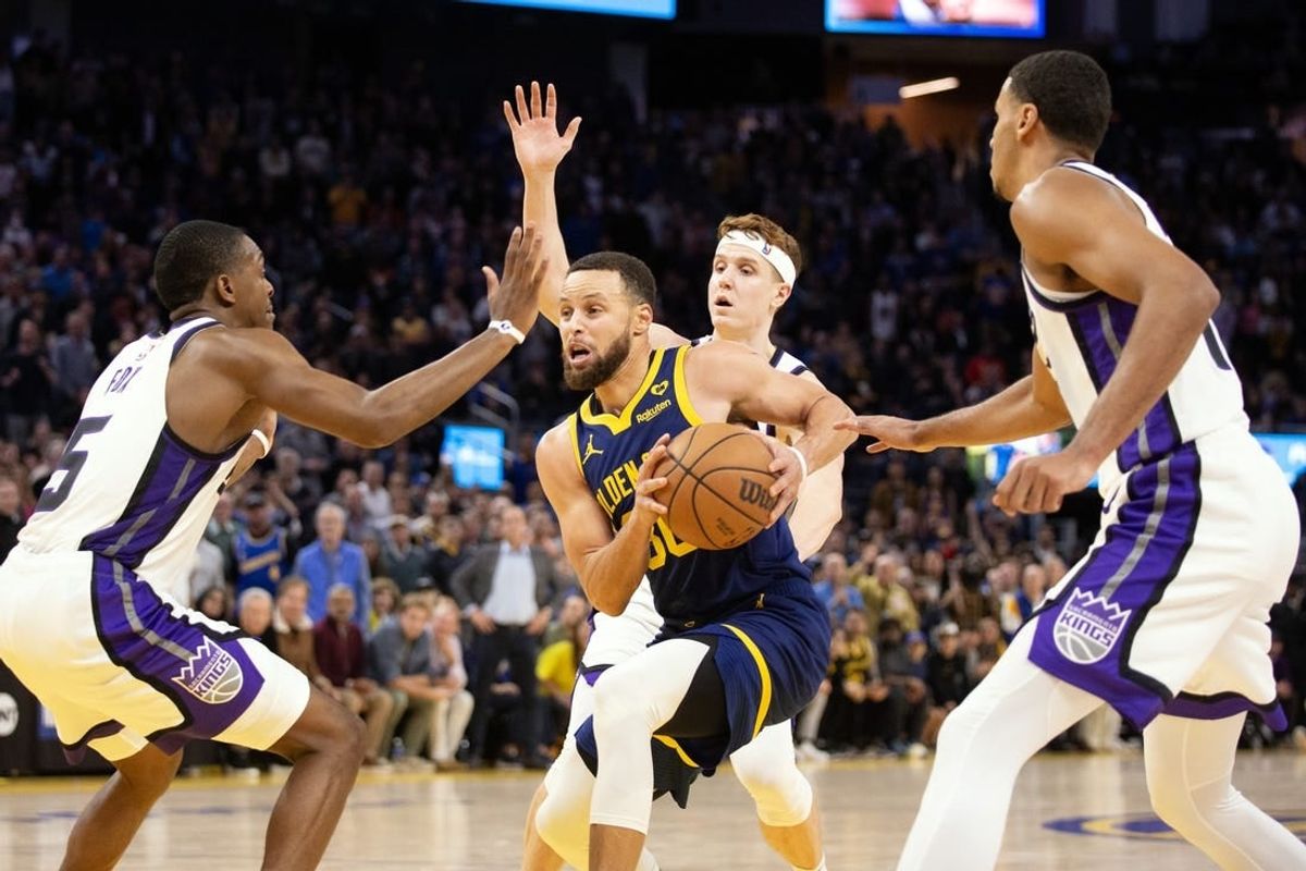 Jan 25, 2024; San Francisco, California, USA; Golden State Warriors guard Stephen Curry (30) drives to the basket between a trio of Sacramento Kings defenders during the fourth quarter at Chase Center.