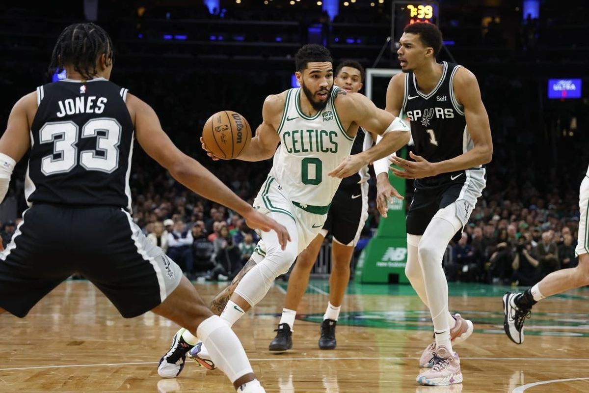 Jan 17, 2024; Boston, Massachusetts, USA; Boston Celtics forward Jayson Tatum (0) drives past San Antonio Spurs center Victor Wembanyama (1) during the second quarter at TD Garden.