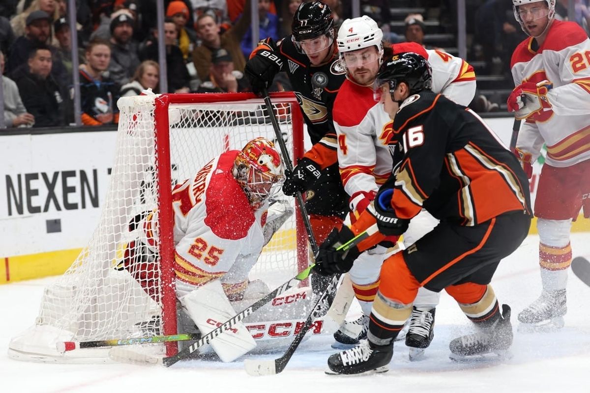 Dec 21, 2023; Anaheim, California, USA;  Calgary Flames goaltender Jacob Markstrom (25) defends the goal against Anaheim Ducks center Ryan Strome (16) and right wing Frank Vatrano (77) during the second period at Honda Center.