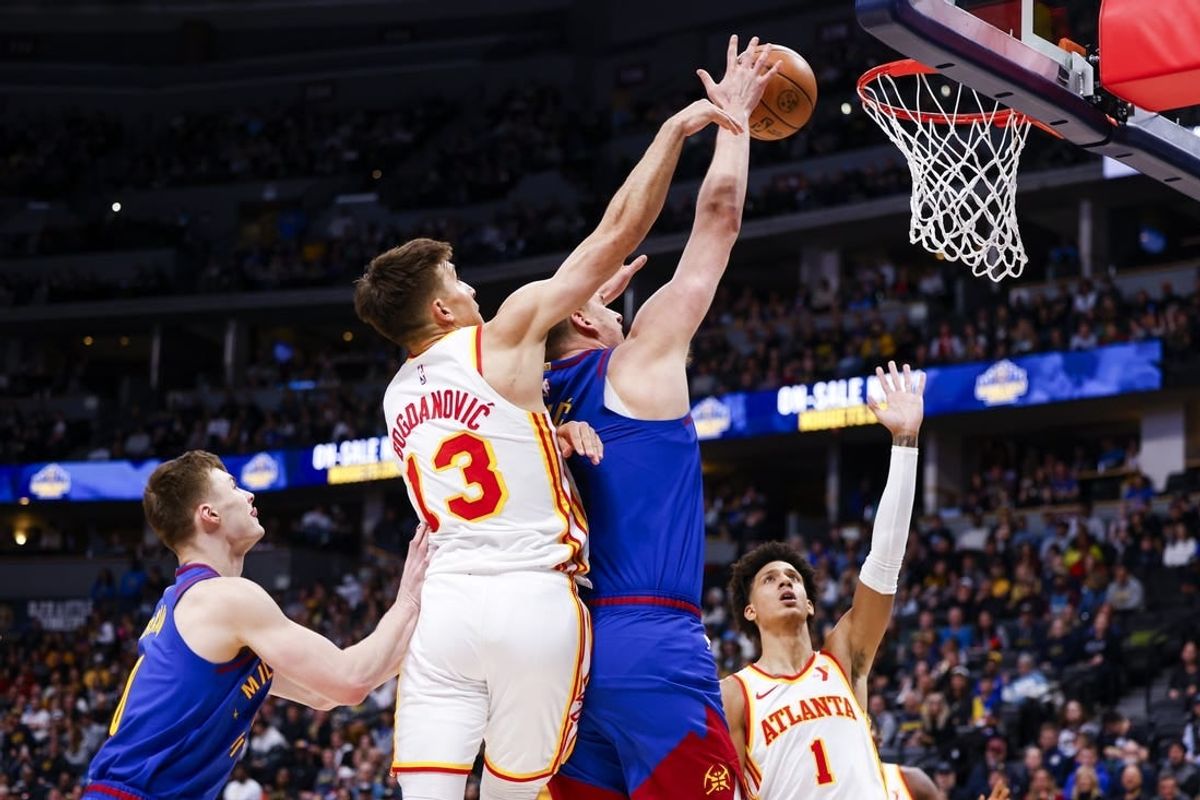 Apr 6, 2024; Denver, Colorado, USA; Denver Nuggets center Nikola Jokic (15) takes a shot while being guarded by Atlanta Hawks guard Bogdan Bogdanovic (13) in the first half at Ball Arena.