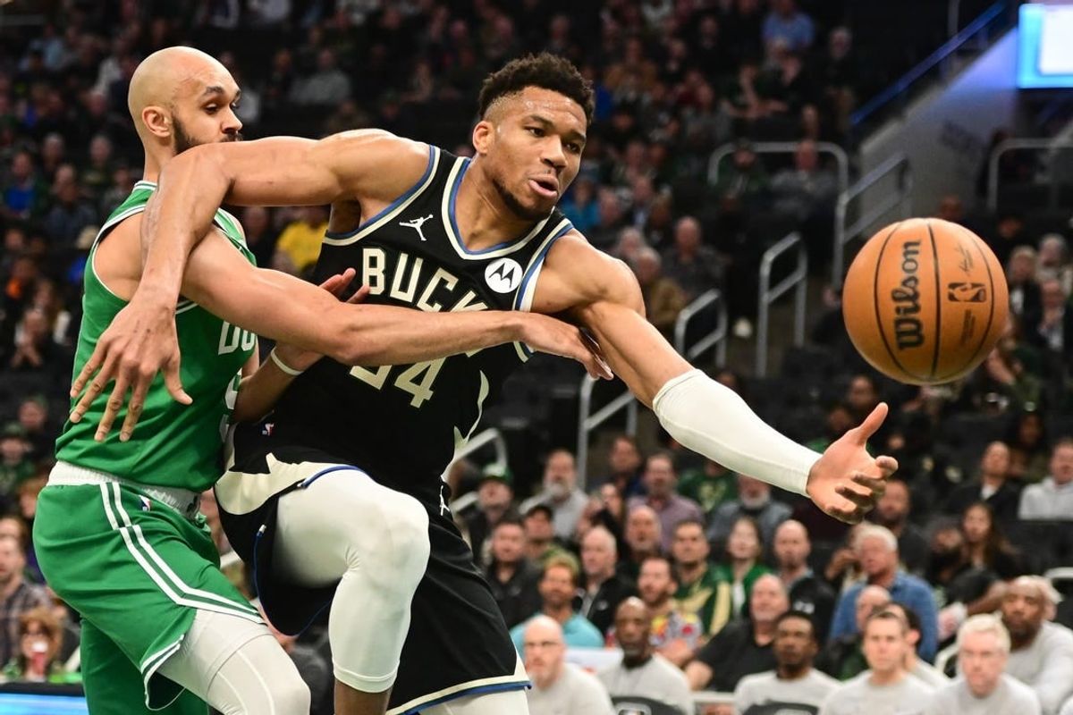Apr 9, 2024; Milwaukee, Wisconsin, USA; Milwaukee Bucks forward Giannis Antetokounmpo (34) and Boston Celtics guard Derrick White (9) reach for the ball in the first quarter at Fiserv Forum.