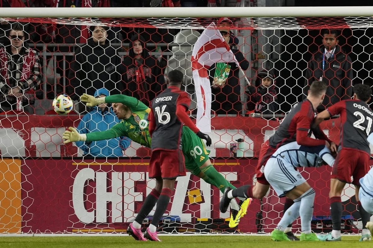Mar 30, 2024; Toronto, Ontario, USA; Toronto FC goalkeeper Luka Gavran (90) dives to make a stop against Sporting Kansas City during the first half at BMO Field.