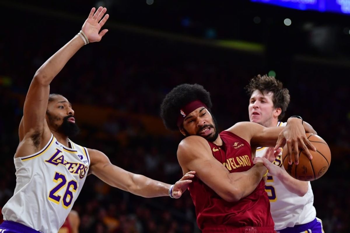 Apr 6, 2024; Los Angeles, California, USA; Los Angeles Lakers guard Austin Reaves (15) and guard Spencer Dinwiddie (26) play for the ball against Cleveland Cavaliers center Jarrett Allen (31) during the first half at Crypto.com Arena.