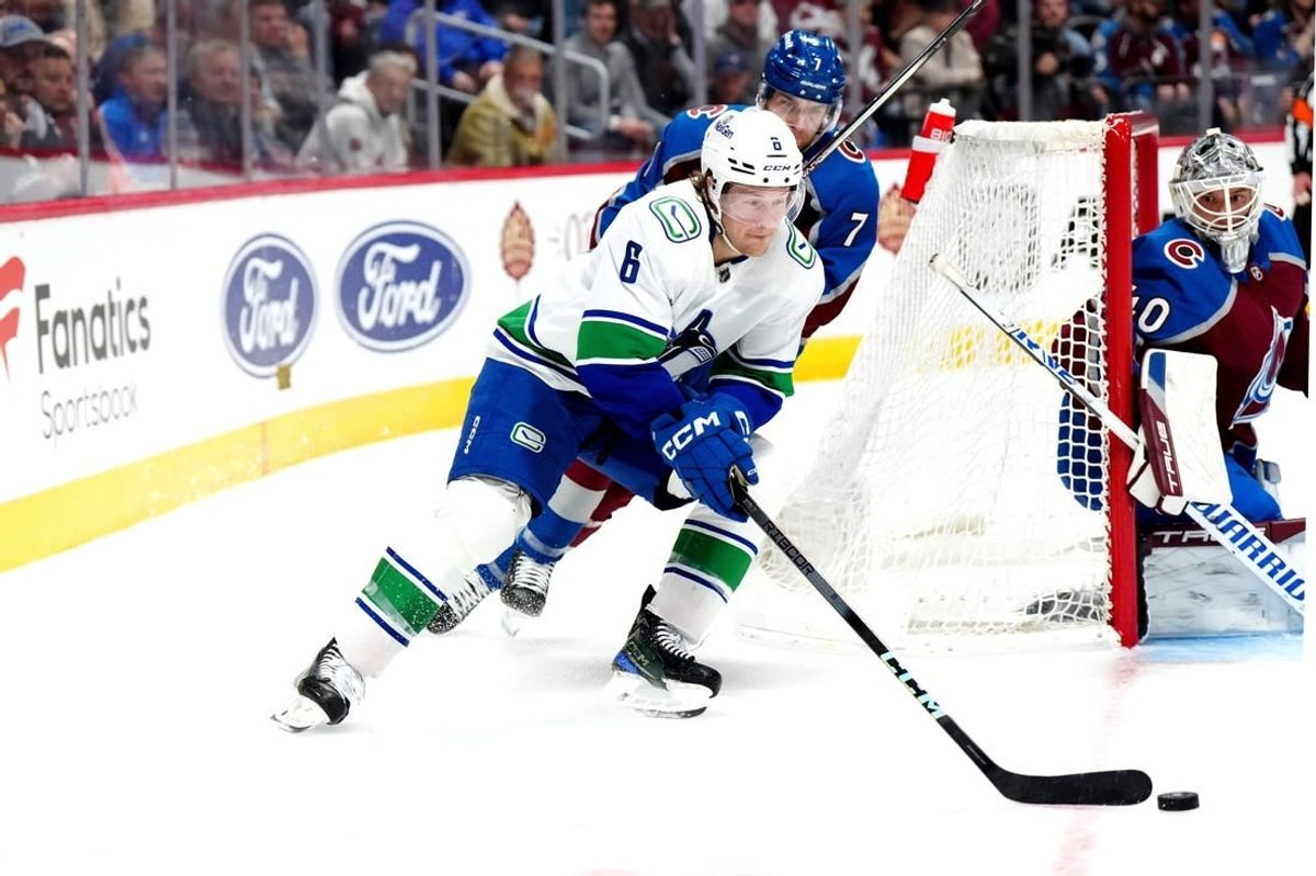 Feb 20, 2024; Denver, Colorado, USA; Vancouver Canucks right wing Brock Boeser (6) skates past Colorado Avalanche defenseman Devon Toews (7) in the third period at Ball Arena.