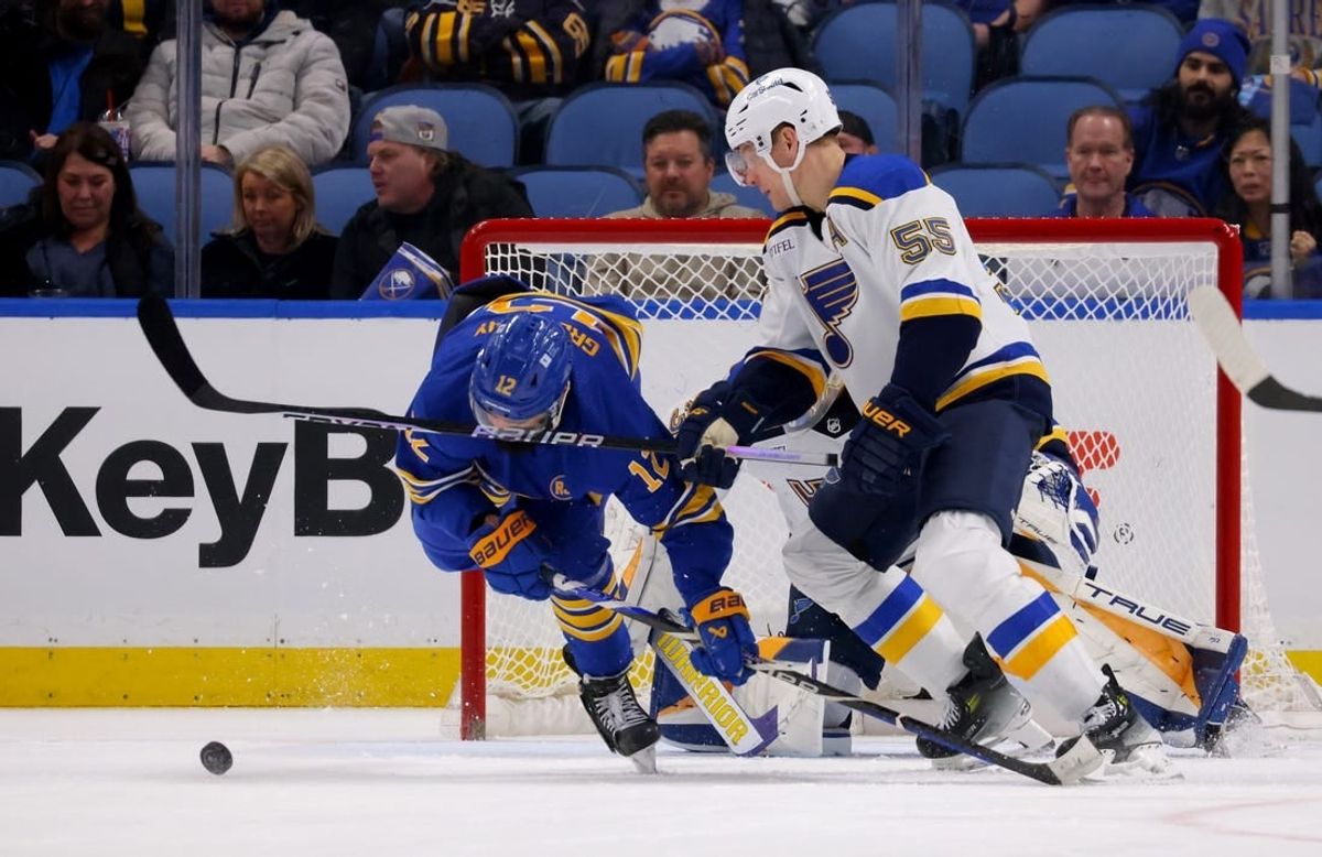 Feb 10, 2024; Buffalo, New York, USA;  Buffalo Sabres left wing Jordan Greenway (12) gets a stick in the face by St. Louis Blues defenseman Colton Parayko (55) as they go after a loose puck during the third period at KeyBank Center.