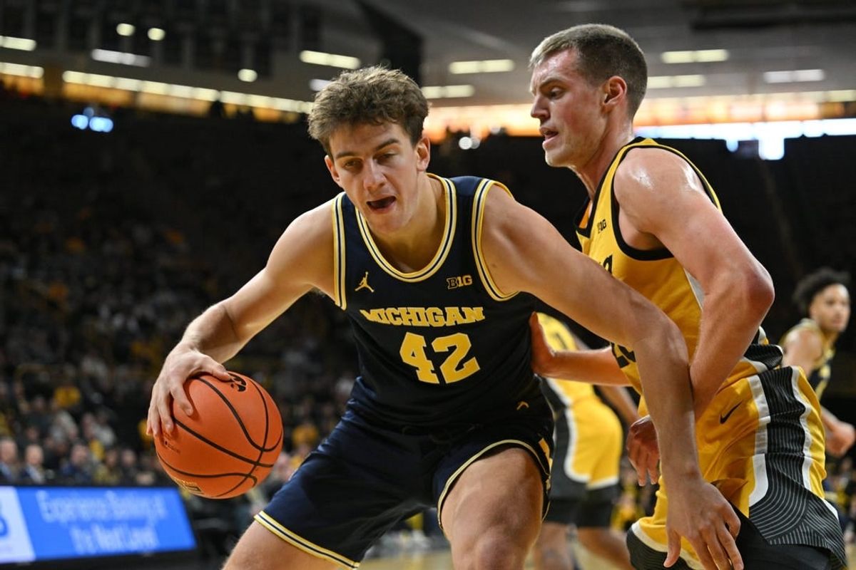 Dec 10, 2023; Iowa City, Iowa, USA; Michigan Wolverines forward Will Tschetter (42) controls the ball as Iowa Hawkeyes forward Payton Sandfort (20) defends during the first half at Carver-Hawkeye Arena.