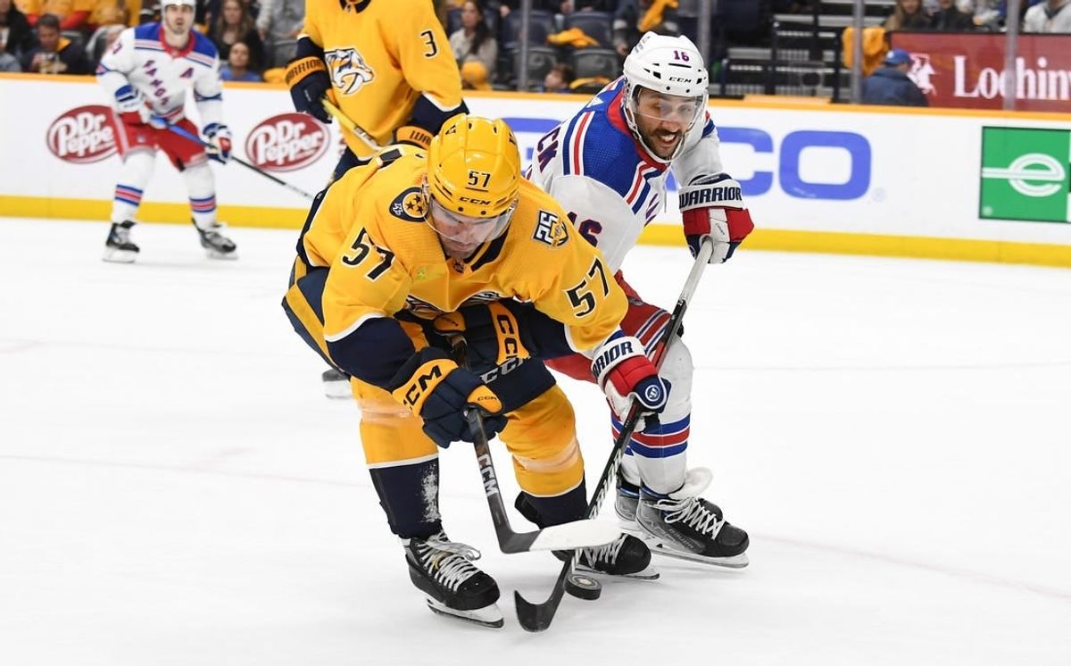 Dec 2, 2023; Nashville, Tennessee, USA; Nashville Predators defenseman Dante Fabbro (57) plays the puck away from New York Rangers center Vincent Trocheck (16) during the second period at Bridgestone Arena.