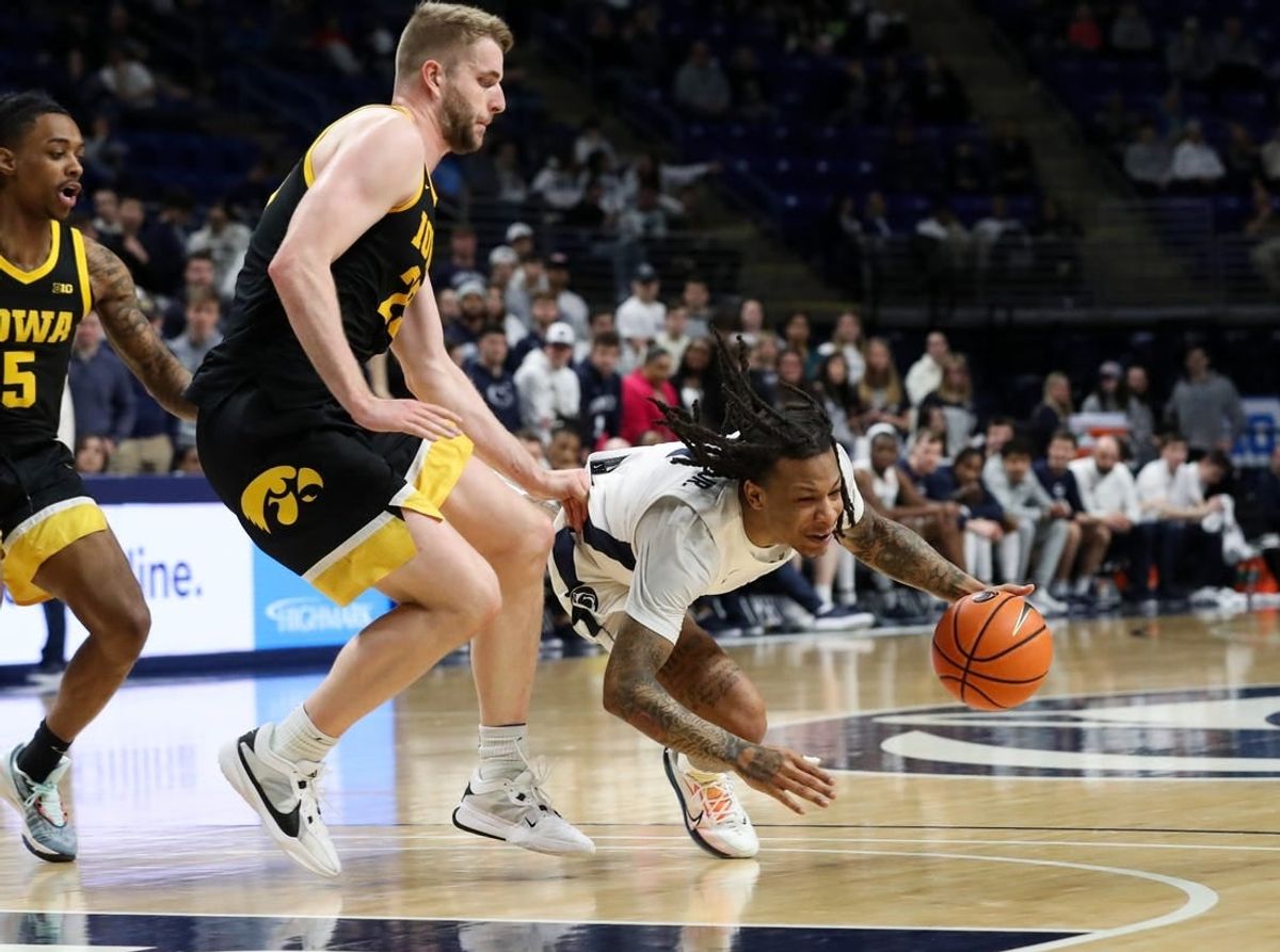 Feb 8, 2024; University Park, Pennsylvania, USA; Penn State Nittany Lions guard Ace Baldwin Jr (1) looses his footing while dribbling the ball around Iowa Hawkeyes forward Ben Krikke (23) during the first half at Bryce Jordan Center.