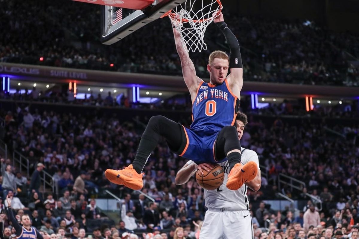 Mar 23, 2024; New York, New York, USA;  New York Knicks guard Donte DiVincenzo (0) dunks in front of Brooklyn Nets forward Cameron Johnson (2) in the fourth quarter at Madison Square Garden.