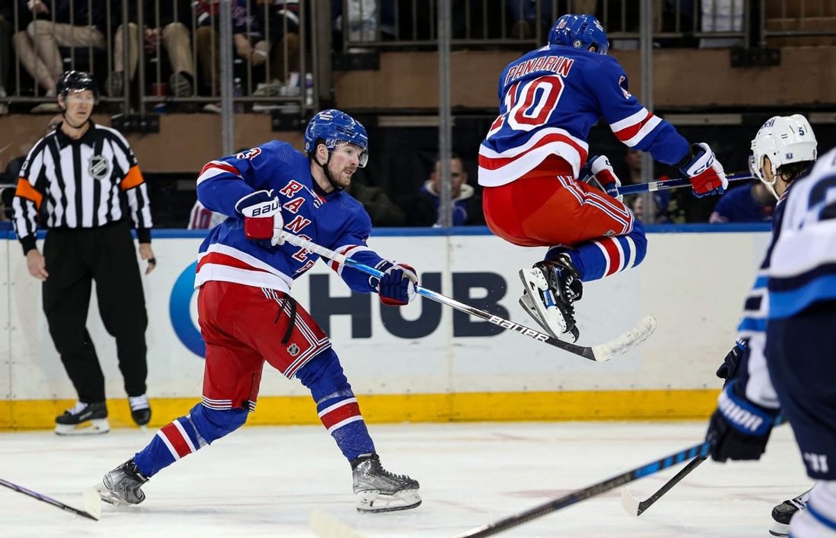 Mar 19, 2024; New York, New York, USA; New York Rangers left wing Artemi Panarin (10) jumps over a shot by New York Rangers forward Alexis Lafreniere (13) during the third period against the Winnipeg Jets at Madison Square Garden.