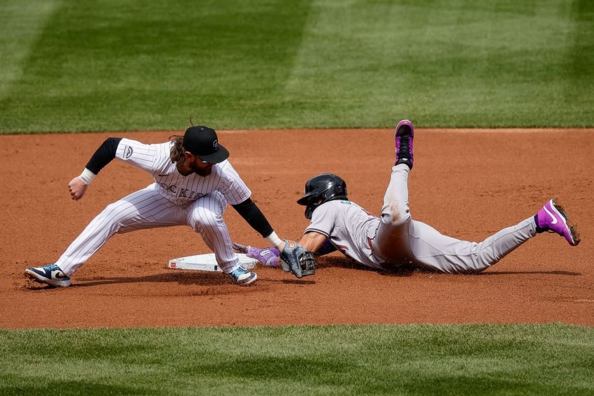 Apr 10, 2024; Denver, Colorado, USA; Arizona Diamondbacks left fielder Lourdes Gurriel Jr. (12) safely steals second against Colorado Rockies second baseman Brendan Rodgers (7) in the first inning at Coors Field.