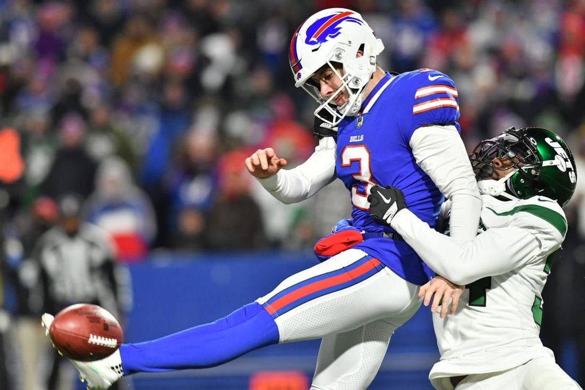 Jan 9, 2022; Orchard Park, New York, USA; Buffalo Bills punter Matt Haack (3) tries to punt the ball while under pressure by New York Jets defensive back Justin Hardee (34)  in the third quarter at Highmark Stadium.