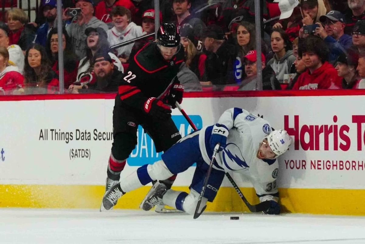 Nov 24, 2023; Raleigh, North Carolina, USA; Carolina Hurricanes defenseman Brett Pesce (22) checks Tampa Bay Lightning left wing Brandon Hagel (38) during the first period at PNC Arena.