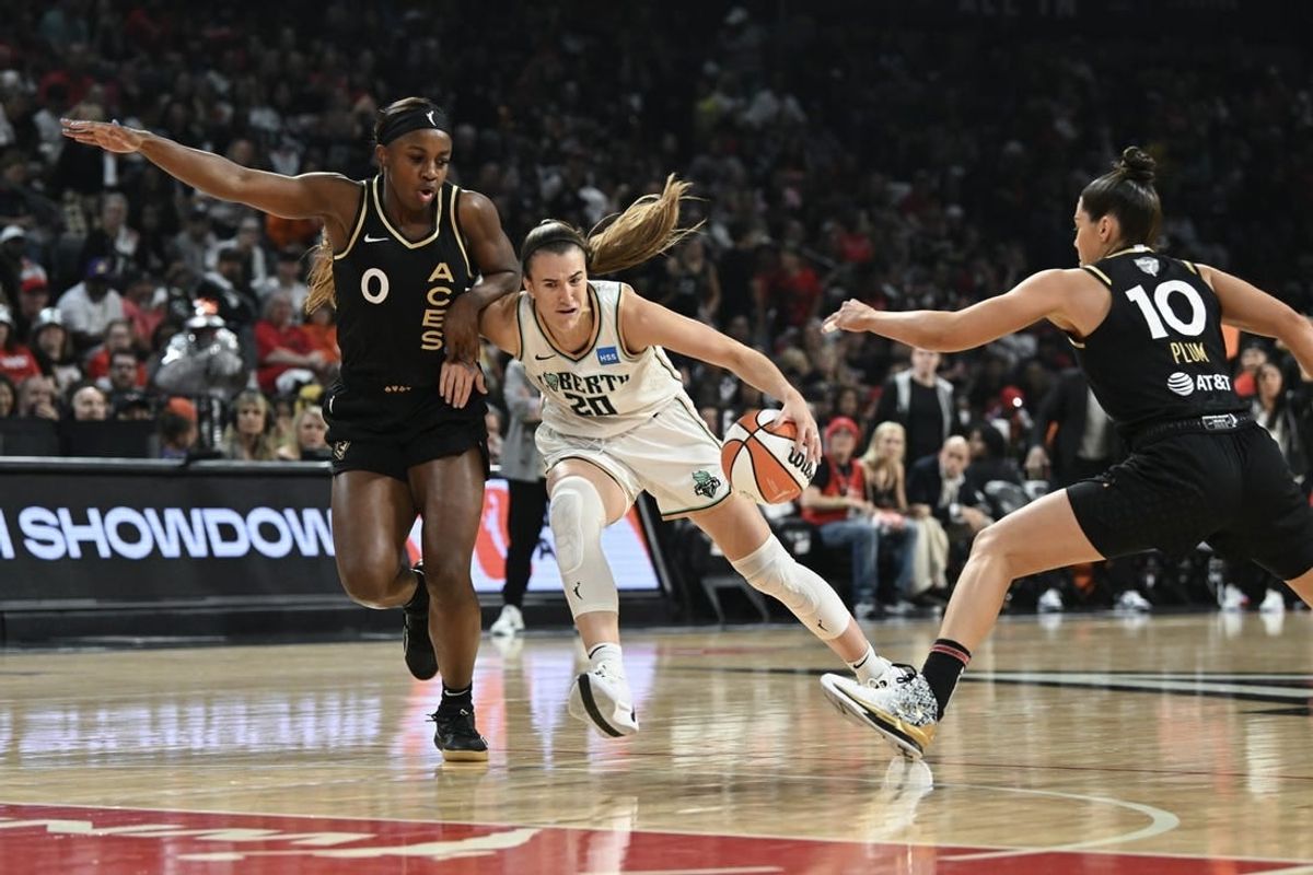 Oct 8, 2023; Las Vegas, Nevada, USA; New York Liberty guard Sabrina Ionescu (20) drives past Las Vegas Aces guard Jackie Young (0) and guard Kelsey Plum (10) in the first half during game one of the 2023 WNBA Finals at Michelob Ultra Arena.