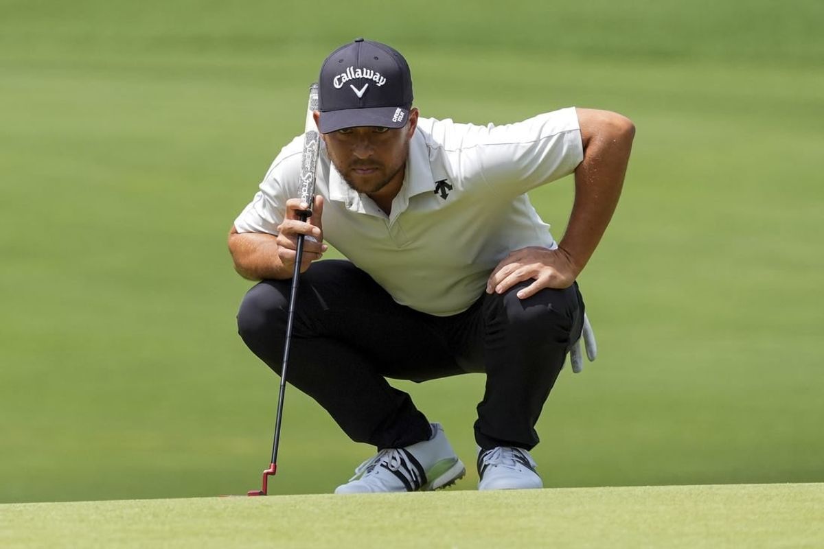 May 11, 2024; Charlotte, North Carolina, USA; Xander Schauffele examines his lie on the fifth green during the third round of the Wells Fargo Championship golf tournament.