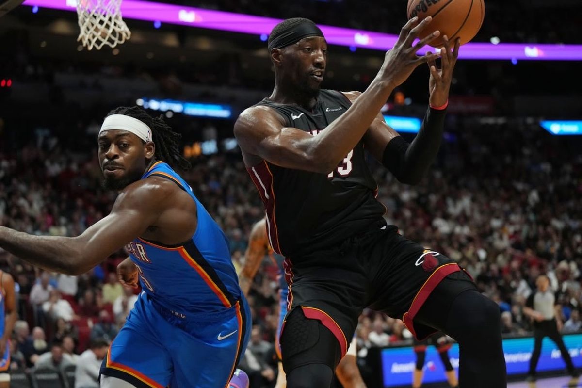 Jan 10, 2024; Miami, Florida, USA; Miami Heat center Bam Adebayo (13) grabs a loose ball as Oklahoma City Thunder guard Luguentz Dort (5) defends during the first half at Kaseya Center.