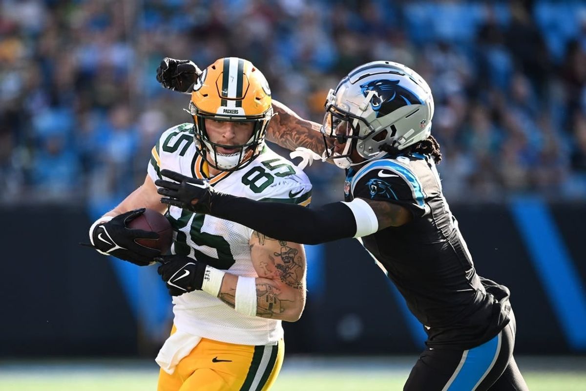 Dec 24, 2023; Charlotte, North Carolina, USA; Green Bay Packers tight end Tucker Kraft (85) is tackled by Carolina Panthers linebacker Brian Burns (0) in the second quarter at Bank of America Stadium.