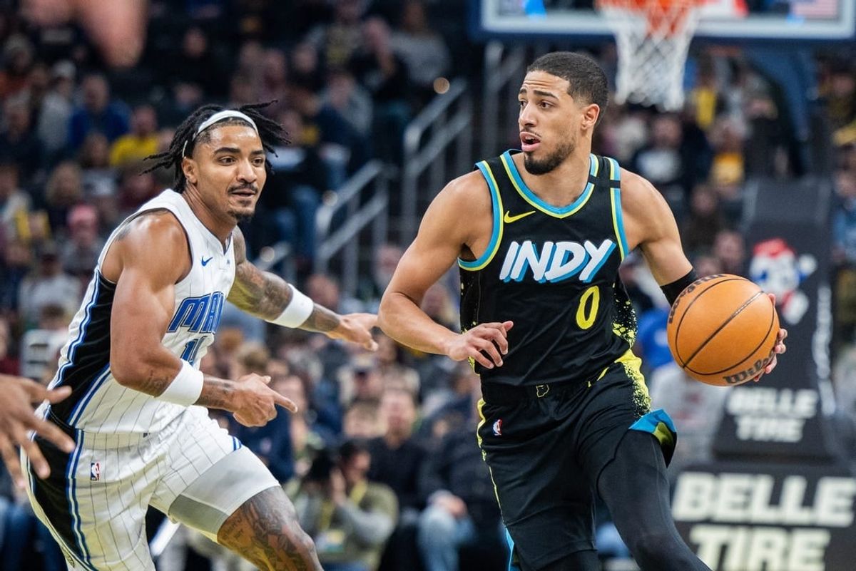 Dec 23, 2023; Indianapolis, Indiana, USA;  Indiana Pacers guard Tyrese Haliburton (0) dribbles the ball while Orlando Magic guard Gary Harris (14) defends in the first quarter at Gainbridge Fieldhouse.