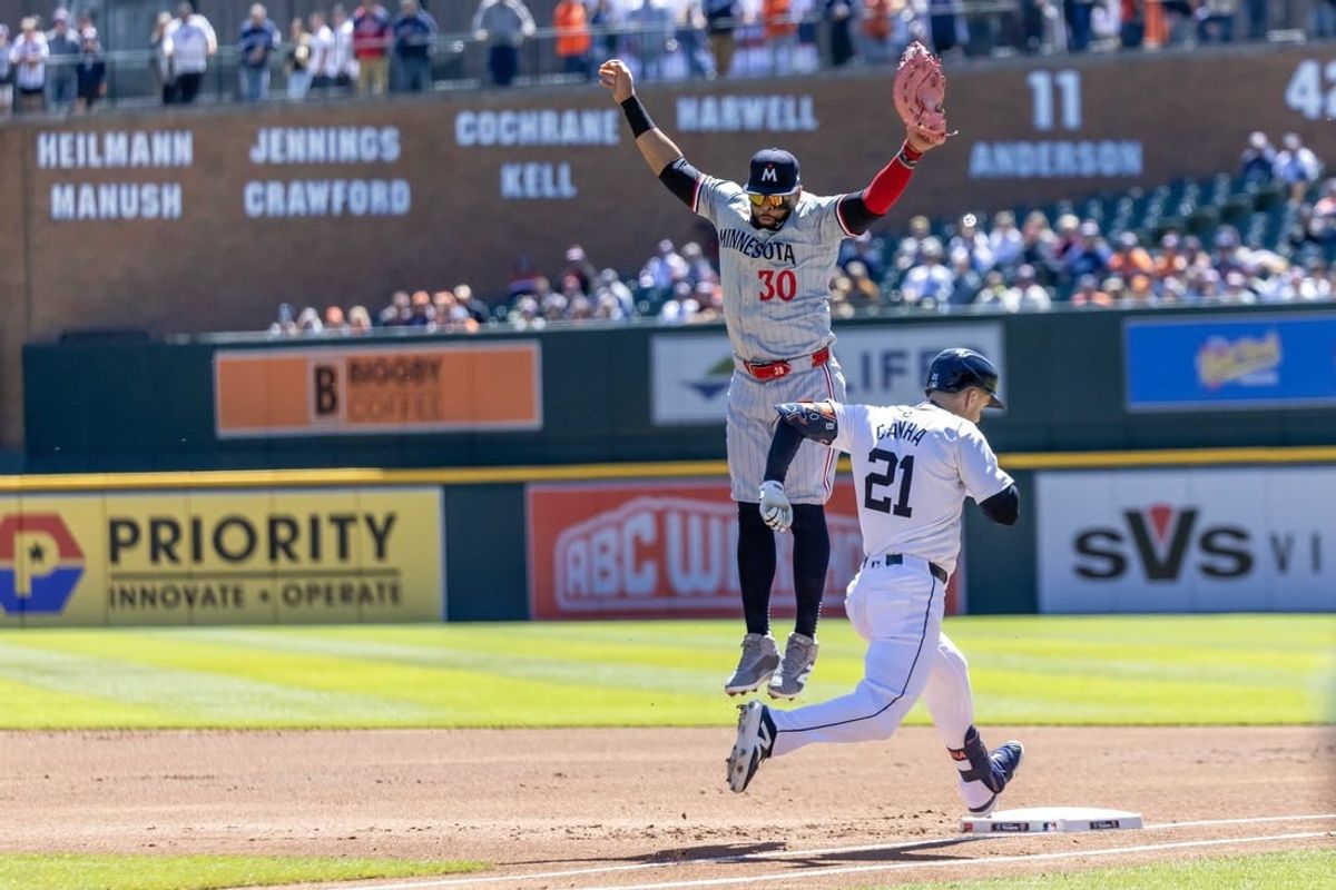 Apr 13, 2024; Detroit, Michigan, USA; Detroit Tigers outfielder Mark Canha (21) beats the throw to Minnesota Twins first base Carlos Santana (30) during game one of a double header at Comerica Park.