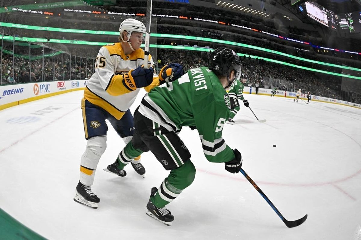 Jan 12, 2024; Dallas, Texas, USA; Nashville Predators center Juuso Parssinen (75) checks Dallas Stars defenseman Nils Lundkvist (5) during the first period at the American Airlines Center.