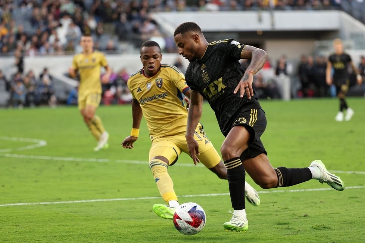 Oct 1, 2023; Los Angeles, California, USA;  Los Angeles FC defender Diego Palacios (12) dribbles the ball against Real Salt Lake forward Carlos Andres Gomez (11) during the first half at BMO Stadium.