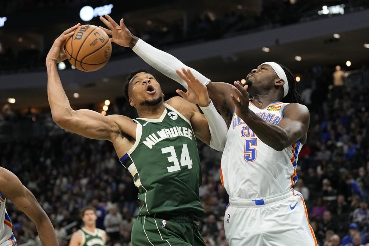 Mar 24, 2024; Milwaukee, Wisconsin, USA;  Milwaukee Bucks forward Giannis Antetokounmpo (34) and Oklahoma City Thunder forward Luguentz Dort (5) reach for a rebound during the third quarter at Fiserv Forum.