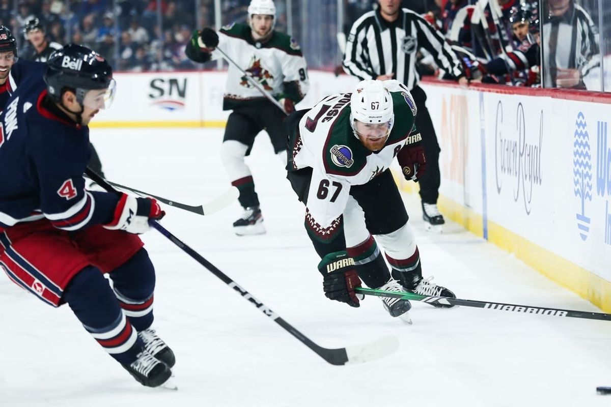 Nov 18, 2023; Winnipeg, Manitoba, CAN; Arizona Coyotes forward Lawson Crouse (67) and Winnipeg Jets defenseman Neal Pionk (4) chase after the puck during the first period at Canada Life Centre.