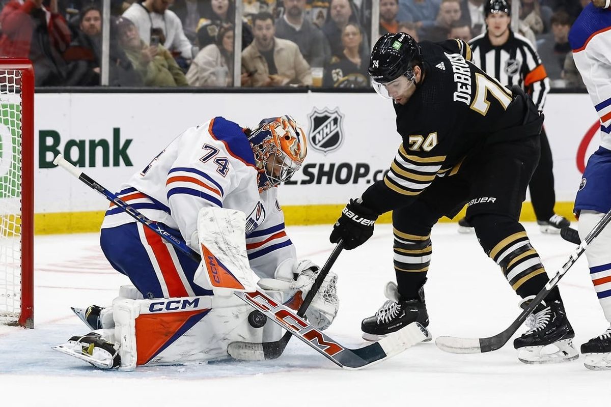 Mar 5, 2024; Boston, Massachusetts, USA; Boston Bruins left wing Jake DeBrusk (74) jams at a rebound at the crease of Edmonton Oilers goaltender Stuart Skinner (74) during the second period at TD Garden.