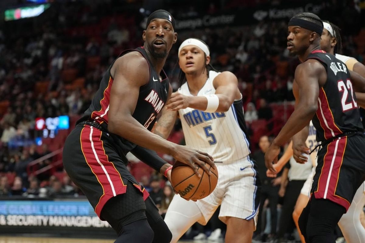 Feb 6, 2024; Miami, Florida, USA;  Miami Heat center Bam Adebayo (13) looks to pass the ball as Orlando Magic forward Paolo Banchero (5) defends during the first half at Kaseya Center.
