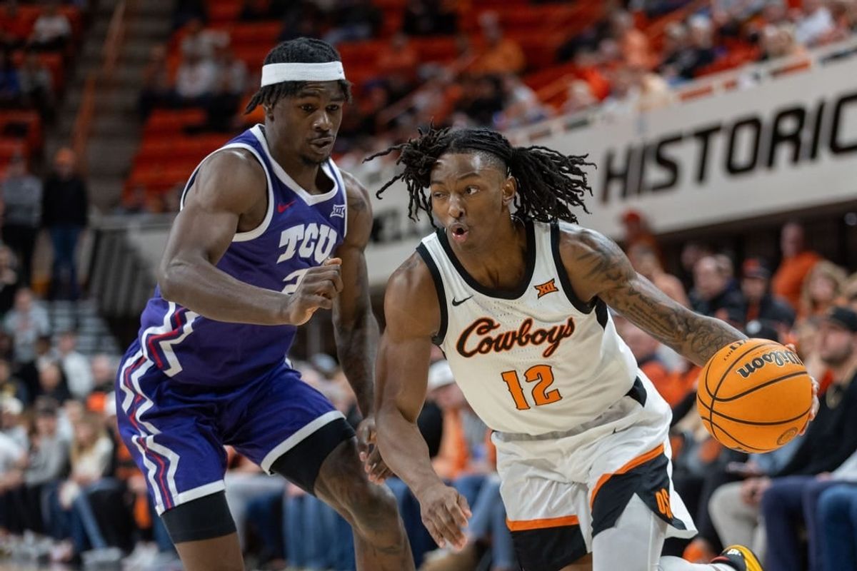 Jan 23, 2024; Stillwater, Oklahoma, USA; Oklahoma State Cowboys guard Javon Small (12) drives around TCU Horned Frogs forward Emanuel Miller (2) during the first half at Gallagher-Iba Arena.
