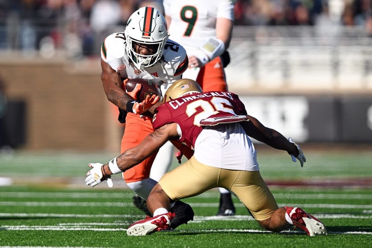 Nov 24, 2023; Chestnut Hill, Massachusetts, USA; Miami Hurricanes running back Henry Parrish Jr. (21) runs against Boston College Eagles defensive back CJ Clinkscales (26) during the first half at Alumni Stadium.
